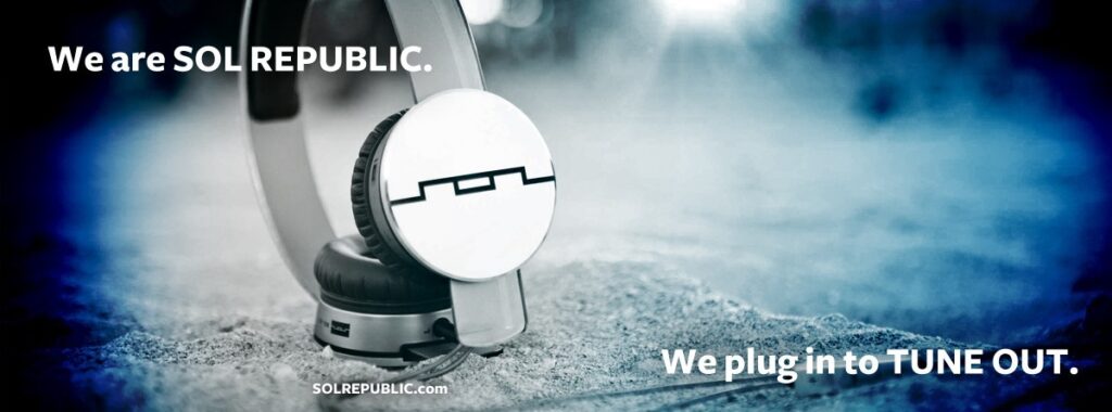 Белые наушники SOL REPUBLIC на асфальте и слоган We plug in to TUNE OUT